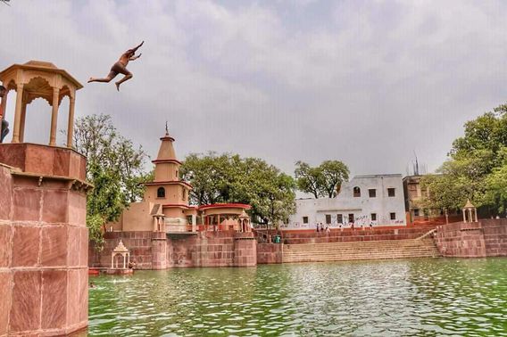Young boy jumping at Peeli Pokhara, Barsana