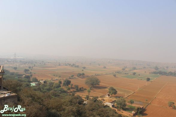 View of open fields along with some houses from the top of Barsana.