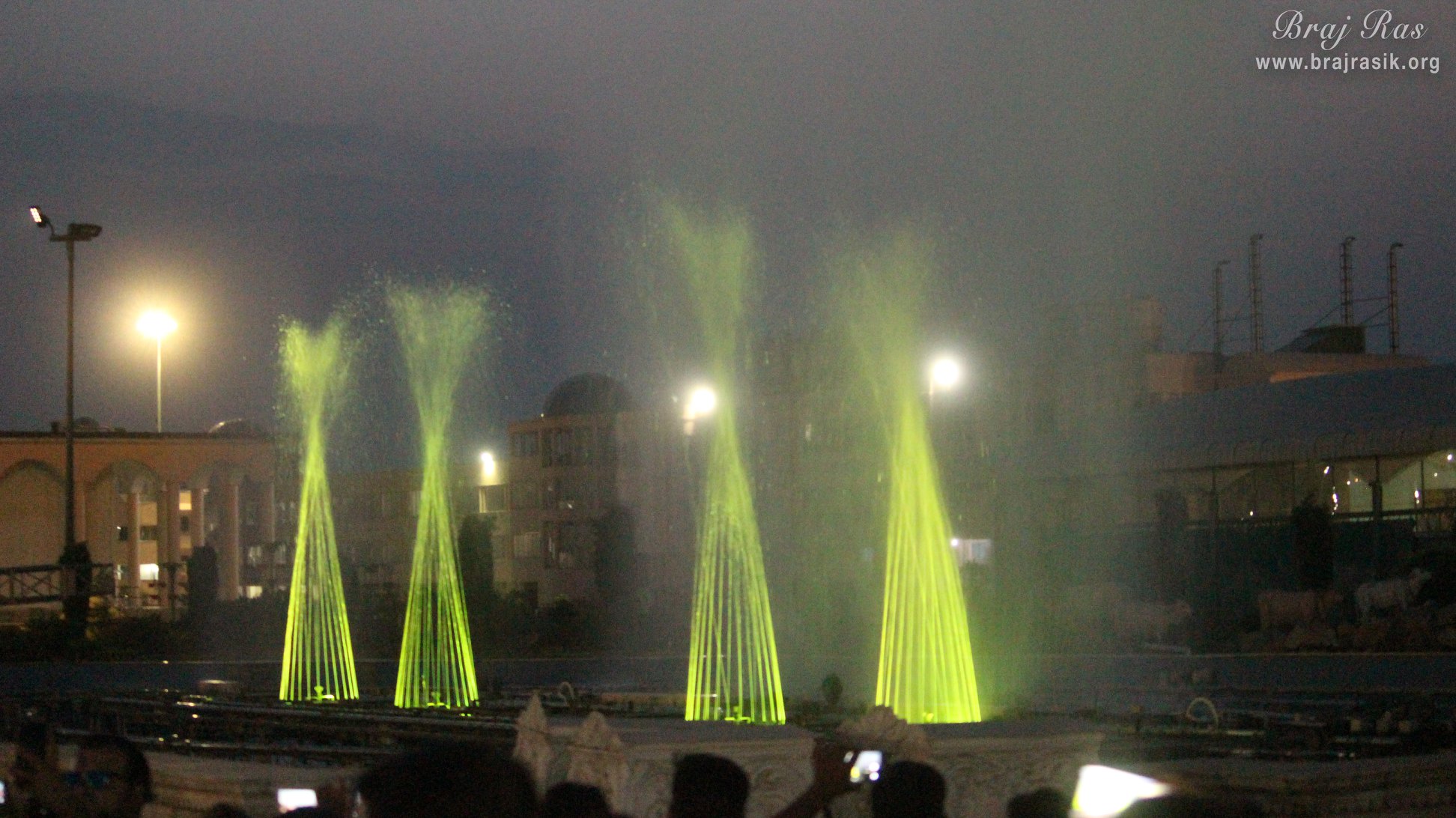 View of water fountains with yellow lightings in evening in Prem Mandir
