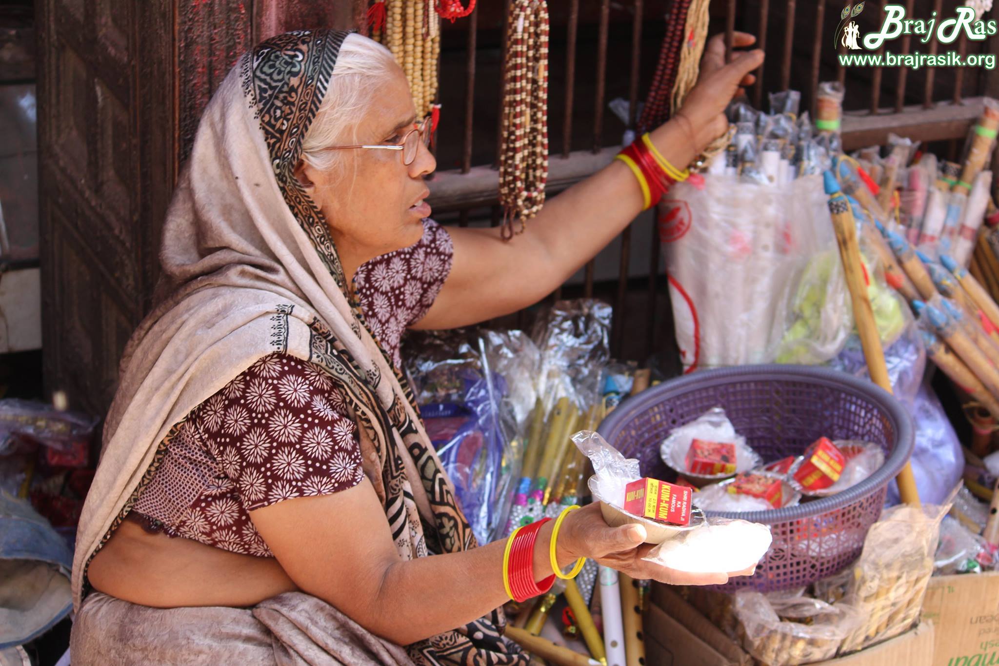 नंदगांव के मंदिर के बाहर पूजा सामग्री बेचती एक ब्रजवासी मैय्या