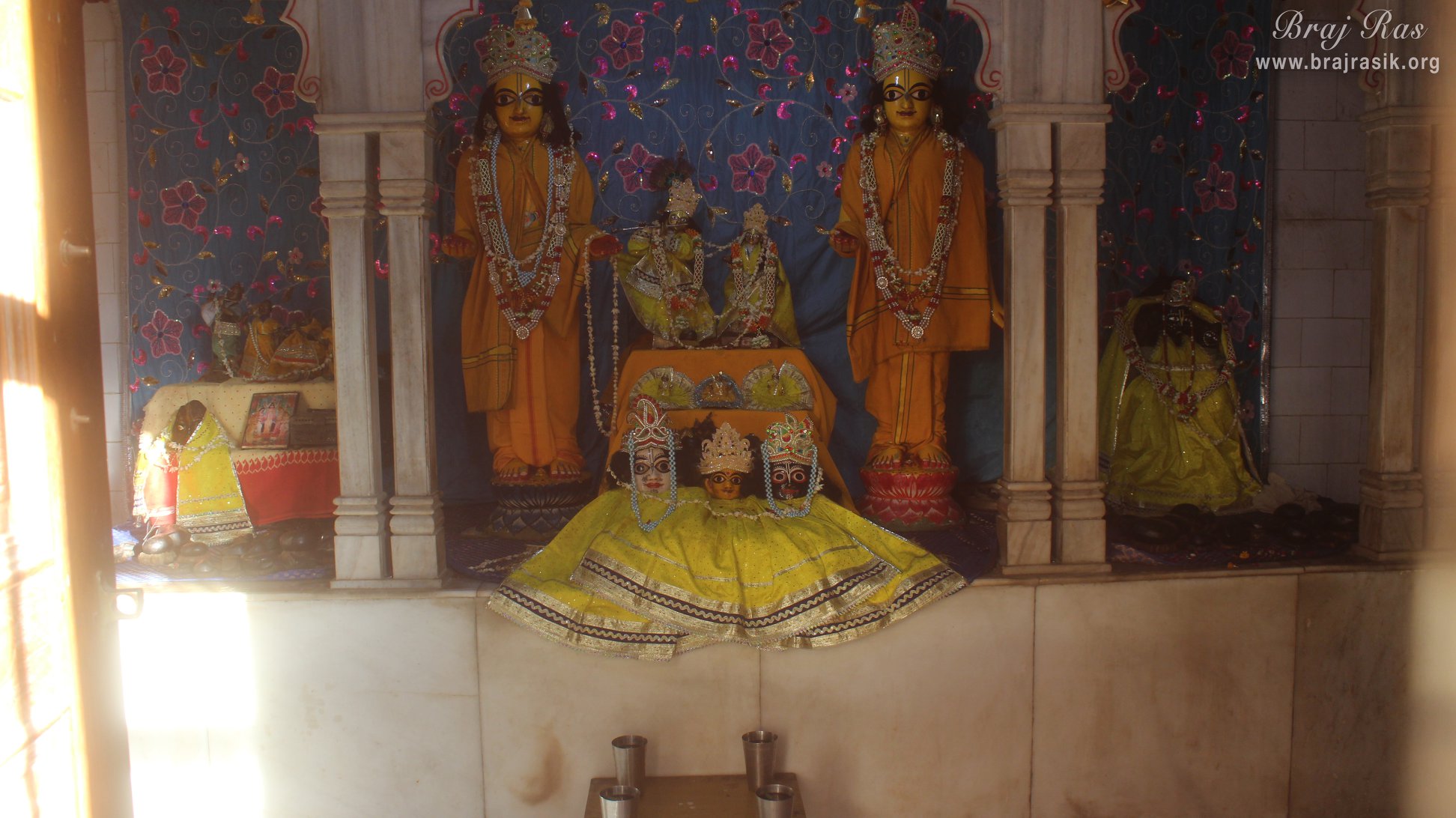 Distant deity darshan in yellow attire at Shringar Vat, Vrindavan