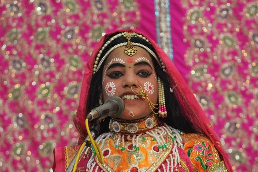 A sakhi of Shri Radha in orange and red attire in Raas Leela, Vrindavan