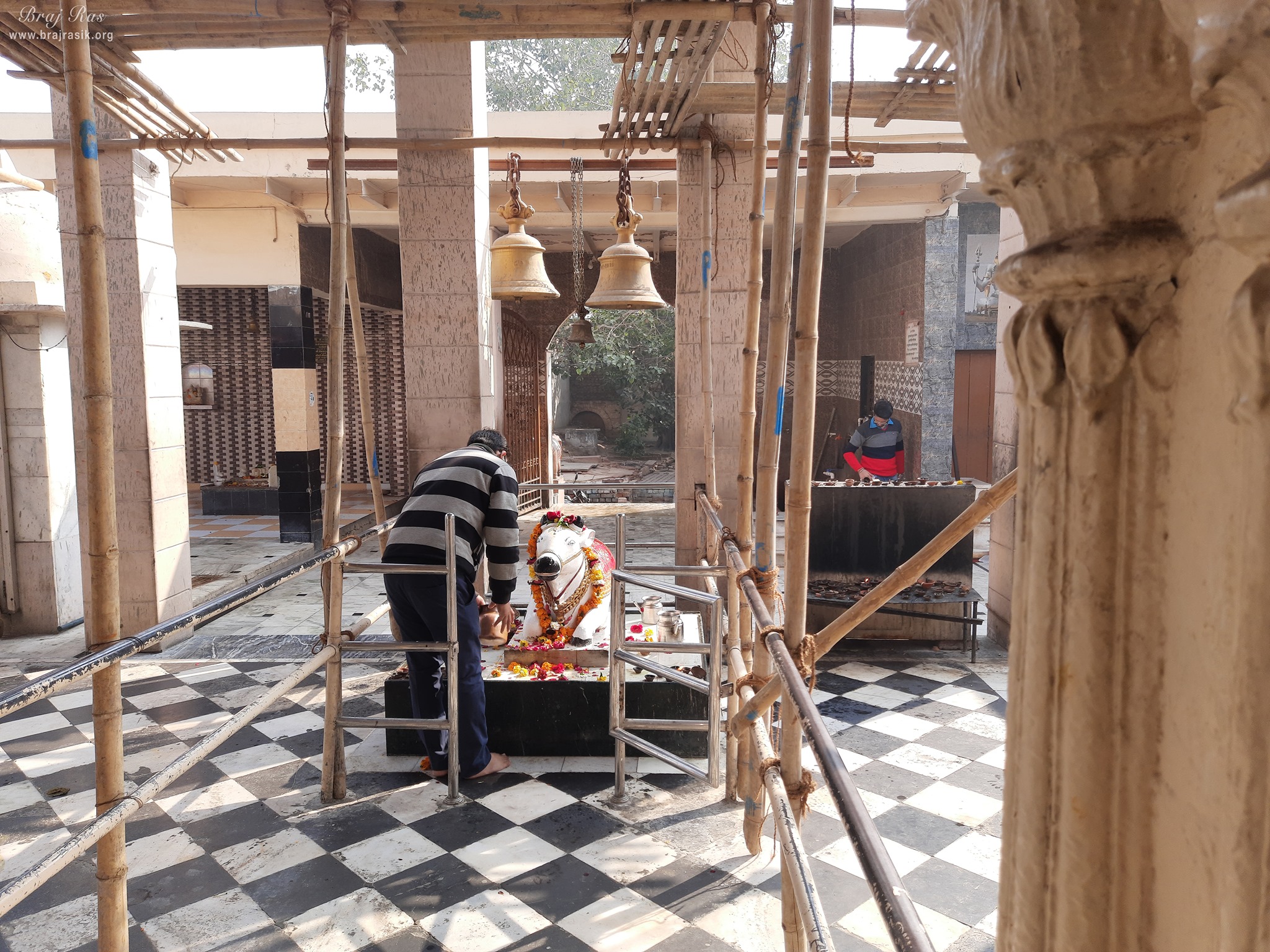 A devotee offering water to Nandi at Bhuteshwar Mahadev Temple, Mathura