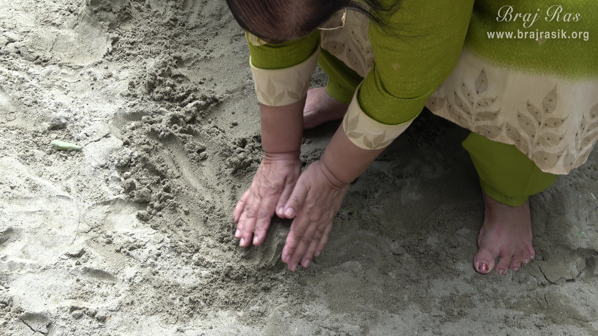 A devotee touching the divine sand at Ramanreti, Gokul - Braj.