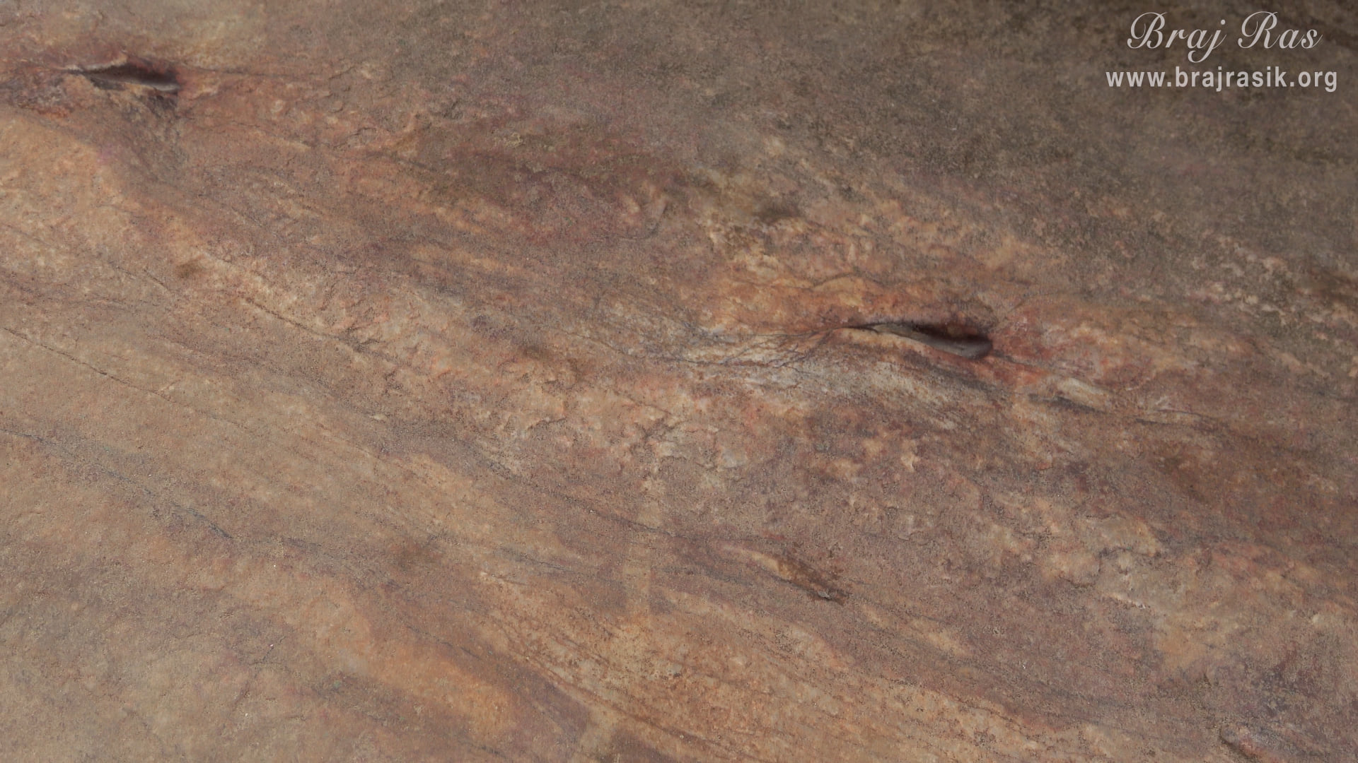 The eyes of Balaram Ji are inscribed on this rock at Mukharvind in Govardhan.
