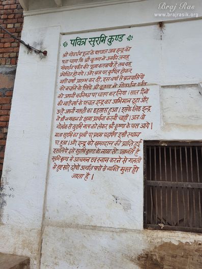 The pastimes of Surbhi Kund in Govardhan is written in Hindi on a wall.
