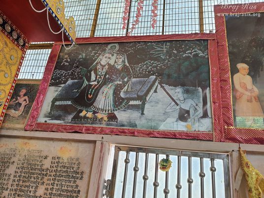 Painting of Shri Shyamashyam hanging on a wall at Radha Bavdi in Vrindavan.