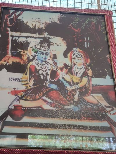 Painting of Shri Radha Krishn seated on the lap of Swami Haridas Ji at Radha Bavdi in Vrindavan.