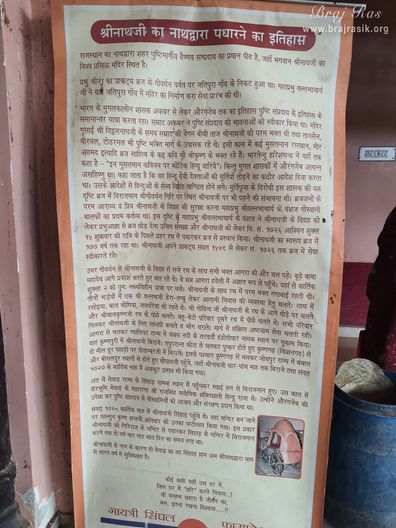 View of a banner containing information about the history of Shrinathji moving to Nathdwara in Shrinathji Temple in Punchari, Govardhan.