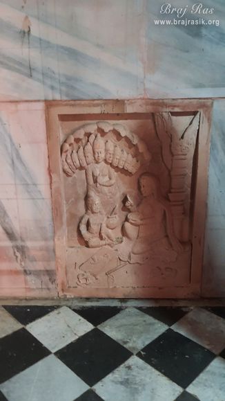 The pastime of Shri Krishn and Mother Yashoda is inscribed on the wall of Brahmand Vihari temple at Brahmand Ghat in Gokul Mahavan.