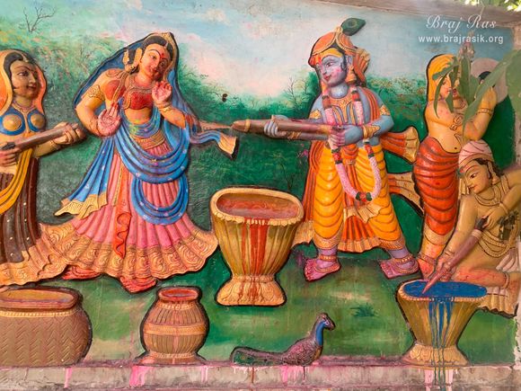 An artwork depicting the Holi pastime of Shri Radha Krishna on the temple wall at Gulal Kund in Gantholi, Govardhan.