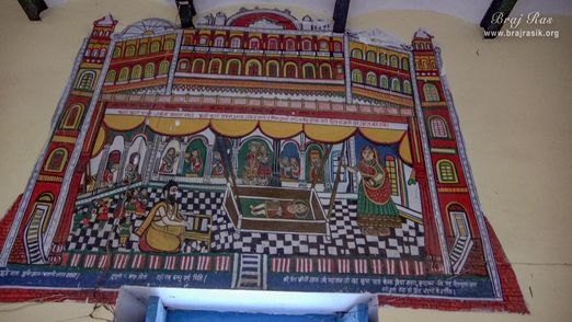 View of a painting of child Harivansh Mahaprabhu swinging in the cradle hanging on the temple wall at the birthplace of Shri Hita Harivansh Mahaprabhu in Baad Gram, Mathura.